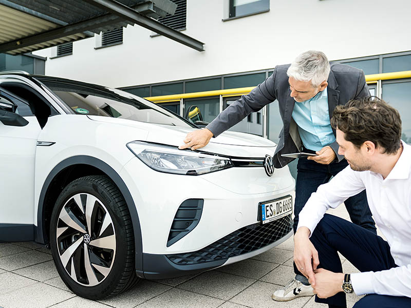 2 Männer begutachten einen VW ID.3, der verkauft werden soll