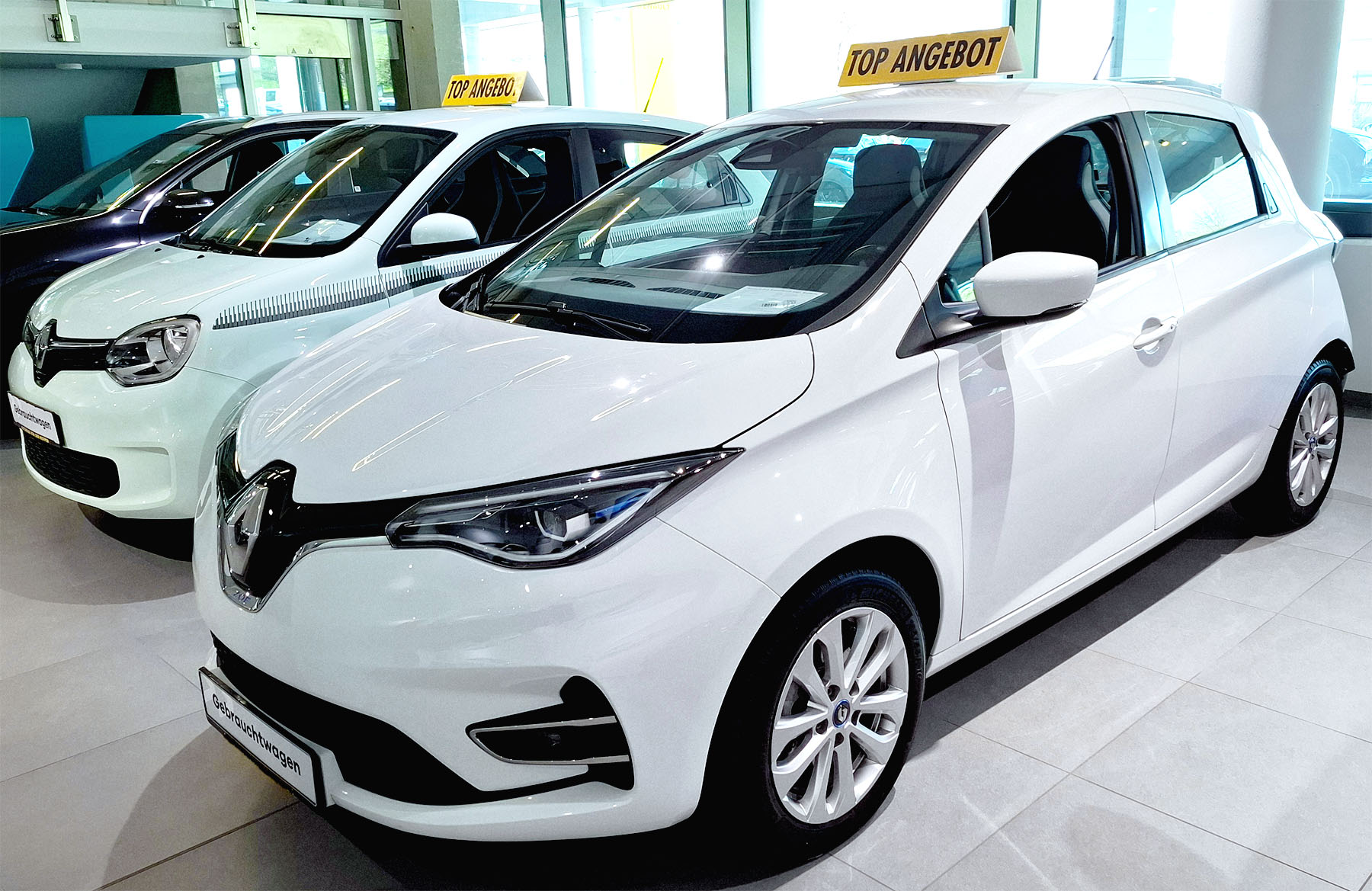 Ein weißer Renault Zoe als Gebrauchtwagen im Showroom eines Autohändlers, ausgezeichnet als Top Angebot